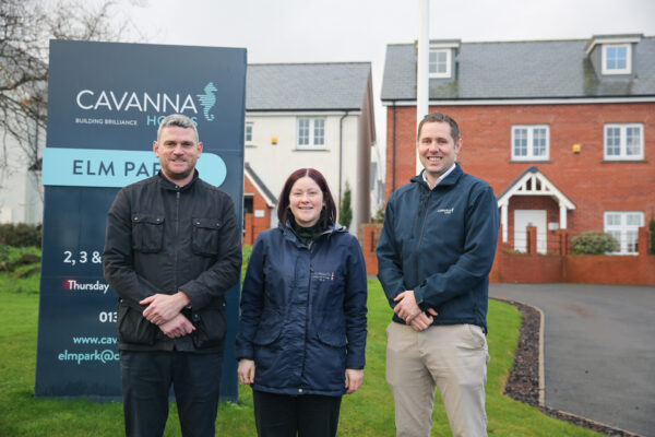 Image of three people in front of a sign for new homes.